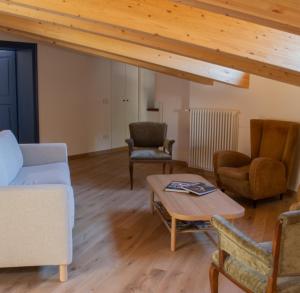 ein Wohnzimmer mit Stühlen und einem Couchtisch in der Unterkunft B&B Villa Cavallier in Barzio