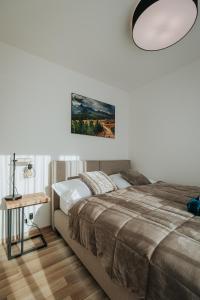 um quarto com uma cama grande e uma mesa em Apartmán Hillside X34, Kubínska Hoľa em Dolný Kubín