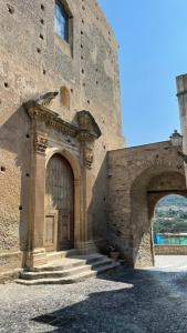 a large stone building with a large wooden door at Residenza Matilde in Fiumefreddo Bruzio