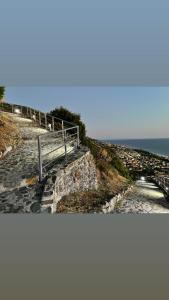 a bench on the side of a hill near the ocean at Residenza Matilde in Fiumefreddo Bruzio