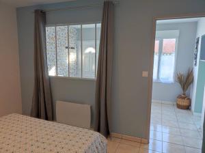 1 dormitorio con cama, ventana y mesa en Gîte Les Deux Ailes, en Saint-Claude-de-Diray