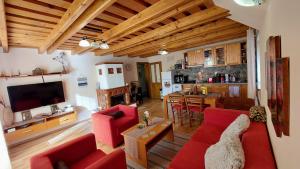 een woonkamer met rode meubels en een keuken bij My TALE apartment in Horná Lehota