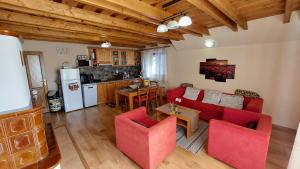 een woonkamer met rode meubels en een keuken bij My TALE apartment in Horná Lehota