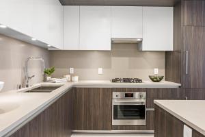 a kitchen with white cabinets and a stove at Level Los Angeles - Downtown Flower in Los Angeles