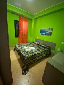 a bedroom with green walls and a bed in it at Appartamento con terrazzo sul mare. in Capo Rizzuto