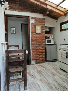 - une cuisine avec un mur en briques et une cuisinière dans l'établissement Las Adelas Chaltén, à El Chalten