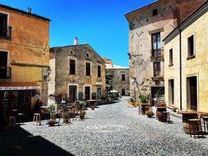 an alley in an old town with tables and chairs at Residenza Matilde in Fiumefreddo Bruzio