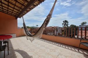a hammock on the balcony of a house at Suites Palmeiras Cabo Frio in Cabo Frio