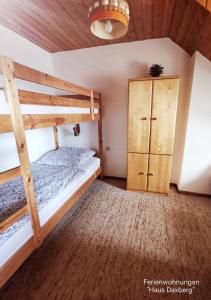 a bedroom with two bunk beds and a cabinet at Ferienwohnungen "Haus Daxberg" Idyllisch gelegen im Bayerischen Wald in Eppenschlag