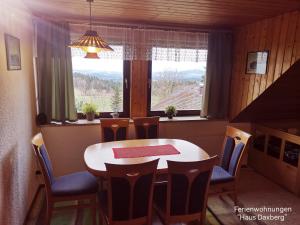 a dining room with a table and chairs and a window at Ferienwohnungen Kremser bei Spiegelau Eppenschlag in Eppenschlag