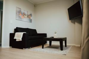 a living room with a black couch and a table at Ferienwohnung Katharinenberg 