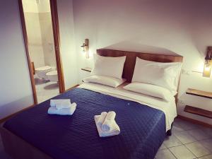 a hotel room with a bed with two slippers on it at Residenza Matilde in Fiumefreddo Bruzio