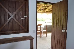 a door leading to a dining room with a table at Hostel e Camping Vale Mirante da Rocha in Timbe do Sul