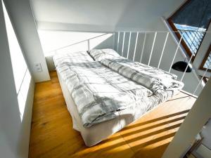 a bed sitting in a room with a window at Apartman Bratrouchov in Jablonec nad Jizerou
