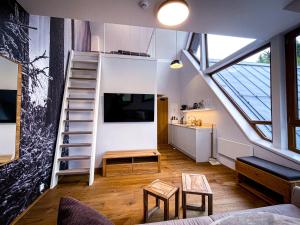 a loft apartment with a staircase and a living room at Apartman Bratrouchov in Jablonec nad Jizerou