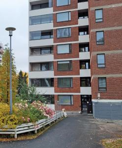 un edificio de ladrillo con un lecho de flores delante de él en Apartment Puijo & autotalli, en Kuopio