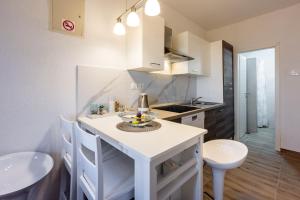 a kitchen with a white counter and a sink at Apartments PERA in Selce
