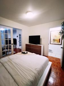 ein Schlafzimmer mit einem großen Bett und einem Flachbild-TV in der Unterkunft Plush 2 bedroom unit 5min Downtown Off Wellington in Montreal