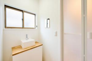 baño blanco con lavabo y ventana en Shinagawa-ku - House - Vacation STAY 13521, en Tokio