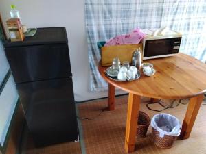 ein kleiner Tisch mit einer Mikrowelle neben einem kleinen Tisch mit einem kleinen sidx-Tisch in der Unterkunft Daramusara - Vacation STAY 13520 in Furano