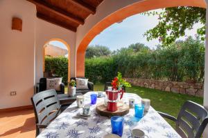 a patio with a table and chairs and an archway at NIULAKA in San Teodoro