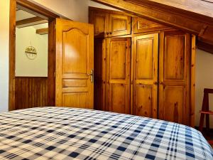 a bedroom with wooden cabinets and a blue and white checkered bed at ÀTIC CASA POMAR in Camprodon