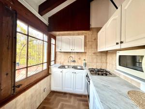 a kitchen with white cabinets and a sink at ÀTIC CASA POMAR in Camprodon