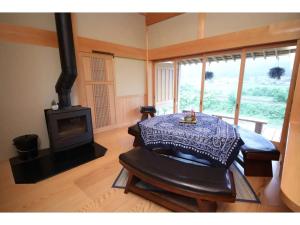 een woonkamer met een fornuis en een tafel bij Villa MITORE-YA - Vacation STAY 13536 in Takayama