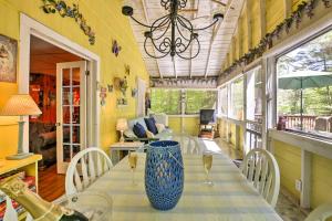 un comedor con una mesa con un jarrón azul en Pet-Friendly Cabin with Fire Pit, BBQ and Great Deck!, en Williamsburg