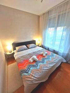 a bedroom with a large bed with two towels on it at Lux Apartman Boris in Zlatibor