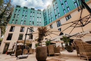 un groupe de chaises et de parasols devant un bâtiment dans l'établissement Kutaisi Inn, à Koutaïssi