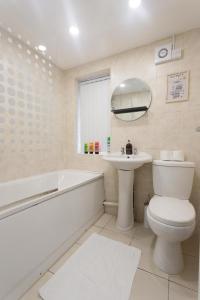 e bagno con servizi igienici, lavandino e vasca. di Beech House Leeds a Leeds