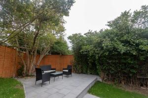 eine Terrasse mit Stühlen, einem Tisch und einem Zaun in der Unterkunft Beech House Leeds in Leeds