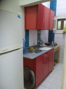 a kitchen with red cabinets and a washing machine at Best appartment in Quseir