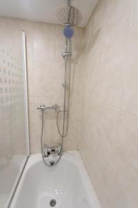 a bathroom with a shower and a white tub at Beech House Leeds in Leeds