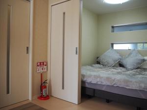 a bedroom with a bed and a door with a window at Harbor City Terrace 202 - Vacation STAY 13565 in Higashi-horidōri