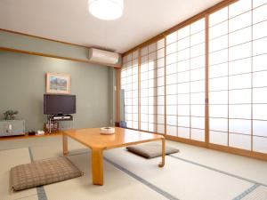 a living room with a table and a tv at Kanko Hotel Yumotokan - Vacation STAY 60199v in Gero