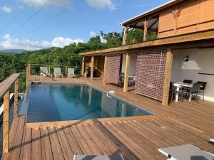 uma piscina num deque de madeira ao lado de uma casa em Kaz Caraibes Bouillante em Bouillante
