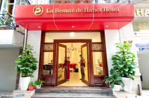 una tienda frente con un toldo rojo en un edificio en La Beaute De Hanoi Hotel, en Hanói