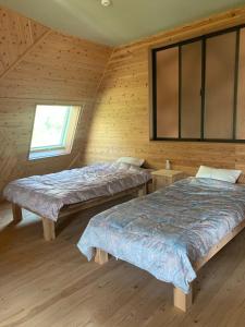 a bedroom with two beds in a wooden cabin at Takahira Base - Vacation STAY 61542v in Yakushima