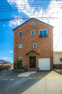 uma grande casa de tijolos com uma garagem branca em Costa Blanca House - Vacation STAY 62301v em Minamiboso