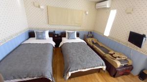 um quarto com duas camas e uma tv nele em Costa Blanca House - Vacation STAY 62301v em Minamiboso