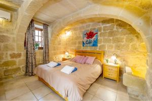 a bedroom with a bed in a stone wall at Ponderosa Holiday Home in Birbuba