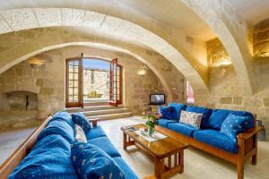 sala de estar con sofá azul y pared de piedra en Ponderosa Holiday Home en Birbuba