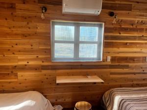 1 dormitorio con pared de madera y ventana en Glamping Village Leaf - Vacation STAY 65726v, en Mashiki