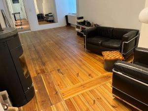 a living room with a black couch and a wooden floor at Schönes Loft mit Kamin in Mitte Gesundbrunnen in Berlin +6 photos
