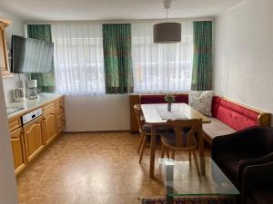 a kitchen with a table and a dining room at Appartements Wieseneck - beste Lage inklusive Sommercard in Ramsau am Dachstein