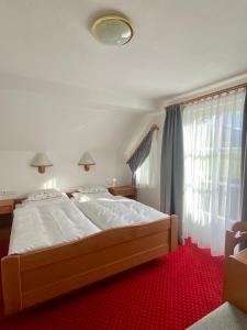 a bedroom with a large bed and a window at Appartements Wieseneck - beste Lage inklusive Sommercard in Ramsau am Dachstein