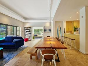 uma sala de estar com uma mesa e um sofá azul em Kite, Wind, Waves Beach Villa em Cidade do Cabo