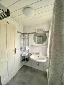 a white bathroom with a sink and a mirror at Appartements Wieseneck - beste Lage inklusive Sommercard in Ramsau am Dachstein